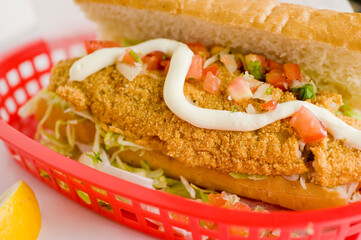 Fried fish or po boy sandwich. Classic Cajun cuisine: fried fish sandwich served on toasted bun w/onions, lettuce, tomato, mayo, salt & pepper. Classic New Orleans sandwich favorite.
