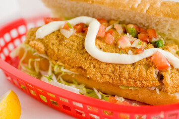 Fried fish or po boy sandwich. Classic Cajun cuisine: fried fish sandwich served on toasted bun w/onions, lettuce, tomato, mayo, salt & pepper. Classic New Orleans sandwich favorite.