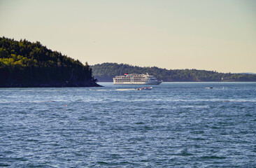 New England cruise to Bar Harbor, Maine on small cruiseship or cruise ship liner in bay with coast...