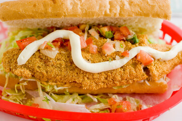 Fried fish or po boy sandwich. Classic Cajun cuisine: fried fish sandwich served on toasted bun w/onions, lettuce, tomato, mayo, salt & pepper. Classic New Orleans sandwich favorite.