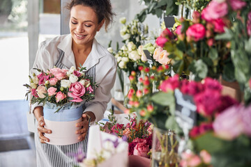 Charming female florist posing with a bunch of pretty flowers