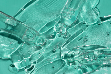 pipettes in a gel texture on a mint green background