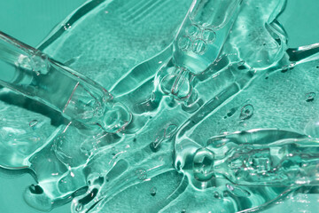 pipettes in a gel texture on a mint green background