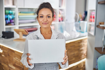 Beautiful lady showing a clear white board to the camera