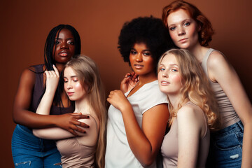 Fototapeta premium young pretty caucasian, afro, scandinavian woman posing cheerful together on brown background, lifestyle diverse nationality people concept