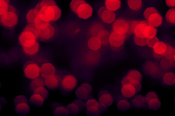 Blurred lights dark neon red background. Abstract bokeh with soft light. Shiny festive christmas texture