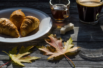 Still life with cup of coffee and fallen leaves and sweets