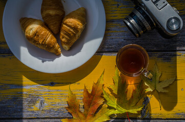 Still life with cup of coffee and fallen leaves and sweets