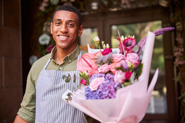 Lively florist handing over a posy of flowers