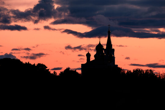 silhouette of the temple on the background of the sunset sky, orange color and clouds