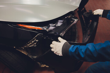 mechanic checks vehicle part in mechanic workshop.