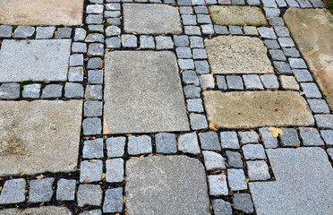 stone paving with a geomentric pattern, a large rectangular tile lined around a smaller cobblestone...