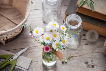 Daisies and forget-me-not flowers bouquet on a gray wooden background