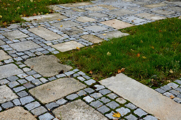 stone paving with a geomentric pattern, a large rectangular tile lined around a smaller cobblestone...