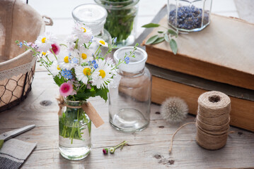 Daisies and forget-me-not flowers bouquet on a gray wooden background