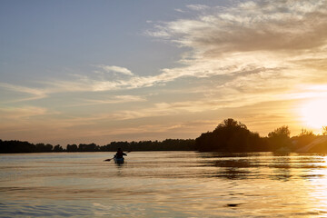 Sillouette of man kayaking on the Danube river at sunset