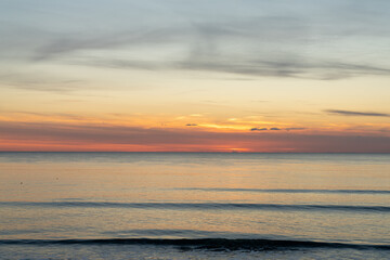 Fototapeta premium beautiful sunset over the ocean with colorful sky and small waves