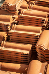 Close-up of stacks of orange roof tiles on a construction site during a renovation. Italy, Europe.