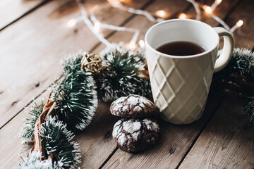 Christmas styled composition. Winter still life. Scandinavian hygge concept. Morning concept. Cozy winter scene with hot tea or coffee and cookies. Flat lay. Home decor.