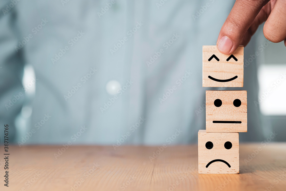 Poster select emotion or mood concept , hand holding smile face or happy face which print screen on wooden 