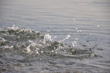 Sea water surface with ripples while splashing item falling into