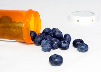 Blueberries spilling from prescription bottle. Healthy concept.