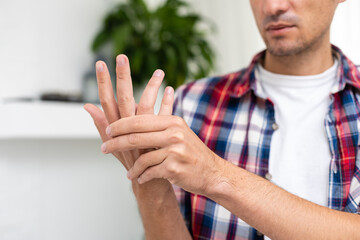 arm is hurting, wrist, man holds a sore hand