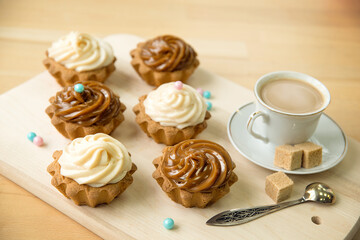Cake baskets with cream and a Cup of coffee on the table.