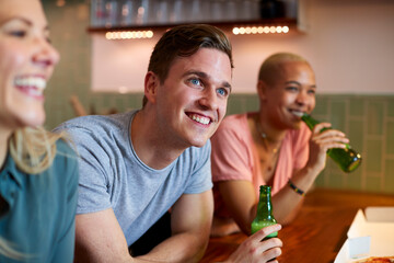 Group Of Friends Celebrating With Beers Meeting At Home And Eating Takeaway Pizza