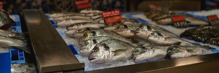 Fresh Fish Carcasses Dorado Lie On Ice Crumbs at supermarket for sale.