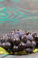 Bunches of dark blue grapes. Lies on black-green pine boards.
