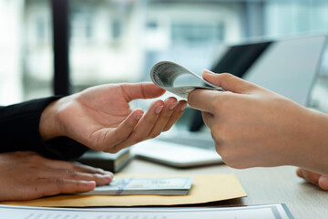 A female accountant or a business woman is giving a male businessman a bribe. And he agreed to...