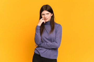 Young Ukrainian girl isolated on yellow background nervous and scared