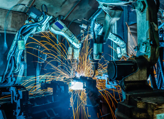 Robots welding in a car factory.