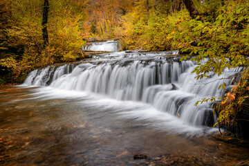 Fototapeta na wymiar beautiful fall forest landscape with idyllic waterfall and pool
