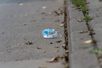 A used face mask is left on the street