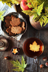 Obraz na płótnie Canvas Autumn food: cinnamon cookies in form of maple leaves, cup of tea, apples and yellow leaves