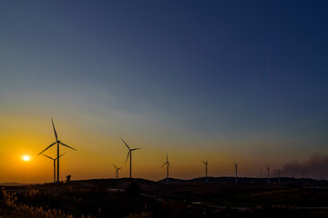 Wind turbine farm over sunset