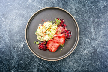 Traditionelle gebratene geräucherte Kalbszunge aufgeschnitten mit Kartoffel Püree und Preiselbeeren angeboten als Draufsicht auf einem Nordic Design Teller mit Textfreiraum 