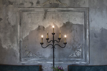 Decorative antique candle light bulbs against cement wall background.