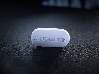 Obraz na płótnie Canvas Clindamycin tablet pill antibiotic on dark background