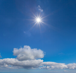 sparkle sun on a blue cloudy sky, natural sky background