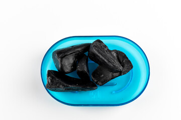 Czarne, pokruszone kawałki mydła.