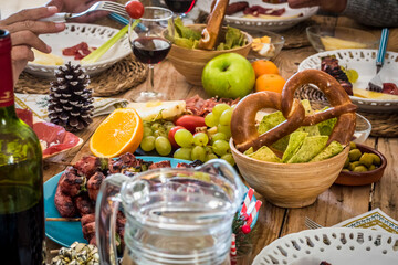Close up of winter decoration christmas eve table full of food and people enjoying party - traditional and celebration concept