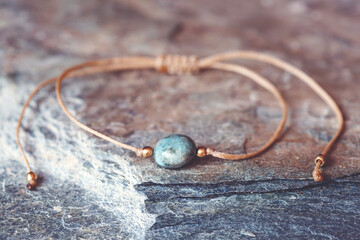 Larimar gemstone natural beads bracelet on grey rocky background