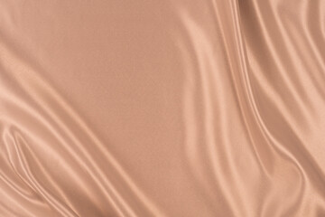 Photography of beautiful elegant wavy beige / light brown satin silk luxury cloth fabric texture, abstract background design. Copy space. Card or banner