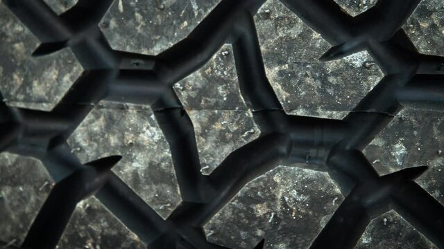 A dolly macro shot of a tire tread pattern, laying down.