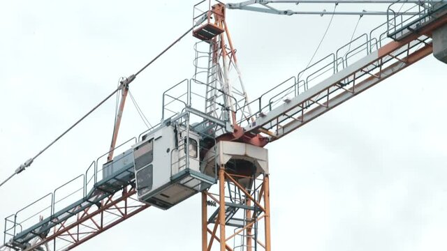 Crane operation at a construction site. Boom operator's landing and load lifting cabins. Worker safety.