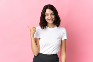Fototapeta premium Teenager Ukrainian girl isolated on pink background pointing to the side to present a product