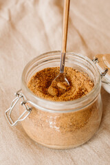 Panela sugar background. Close up view of raw cane sugar in a jar.	